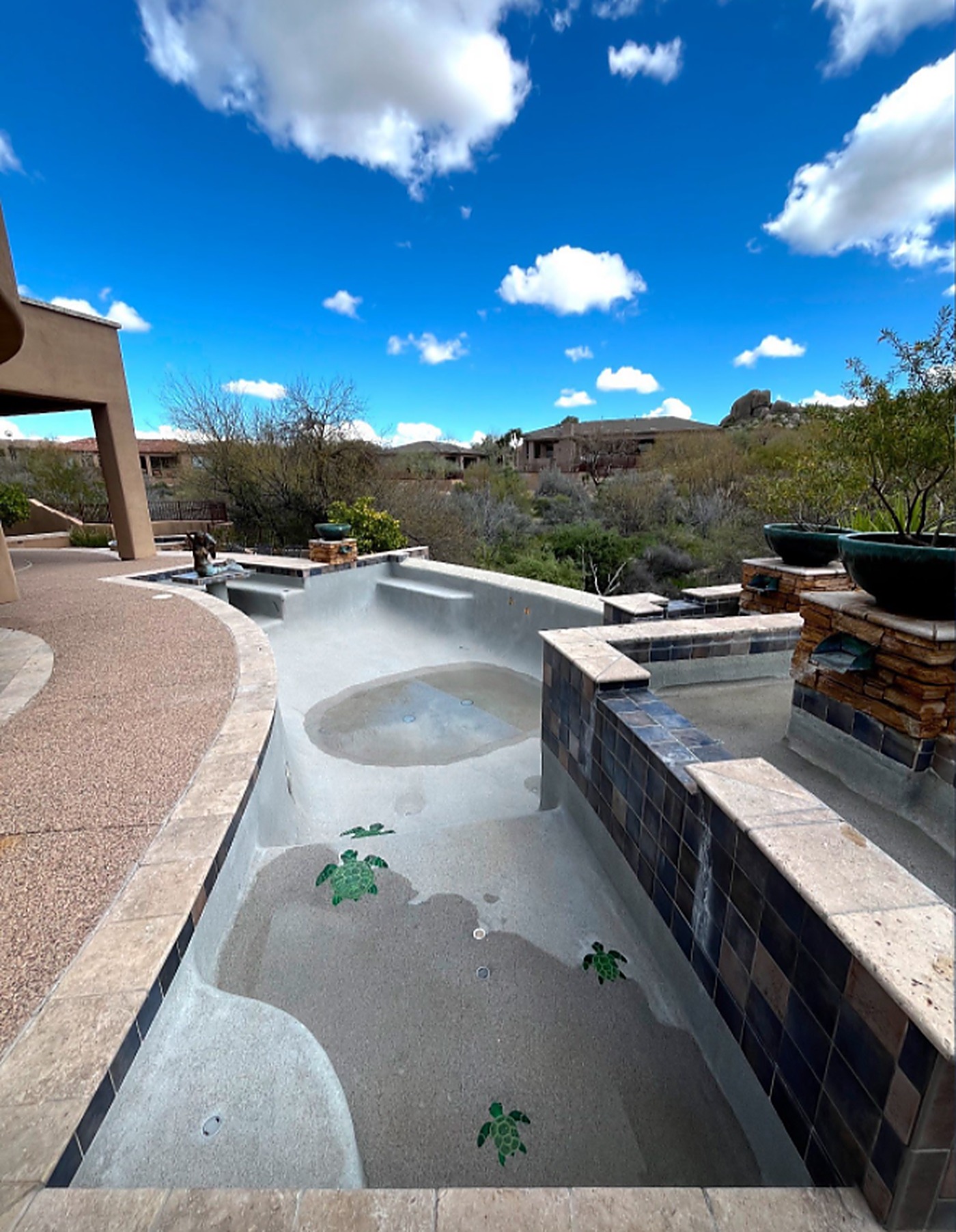 Before: an empty infinity-edge pool with dull, chalky plaster