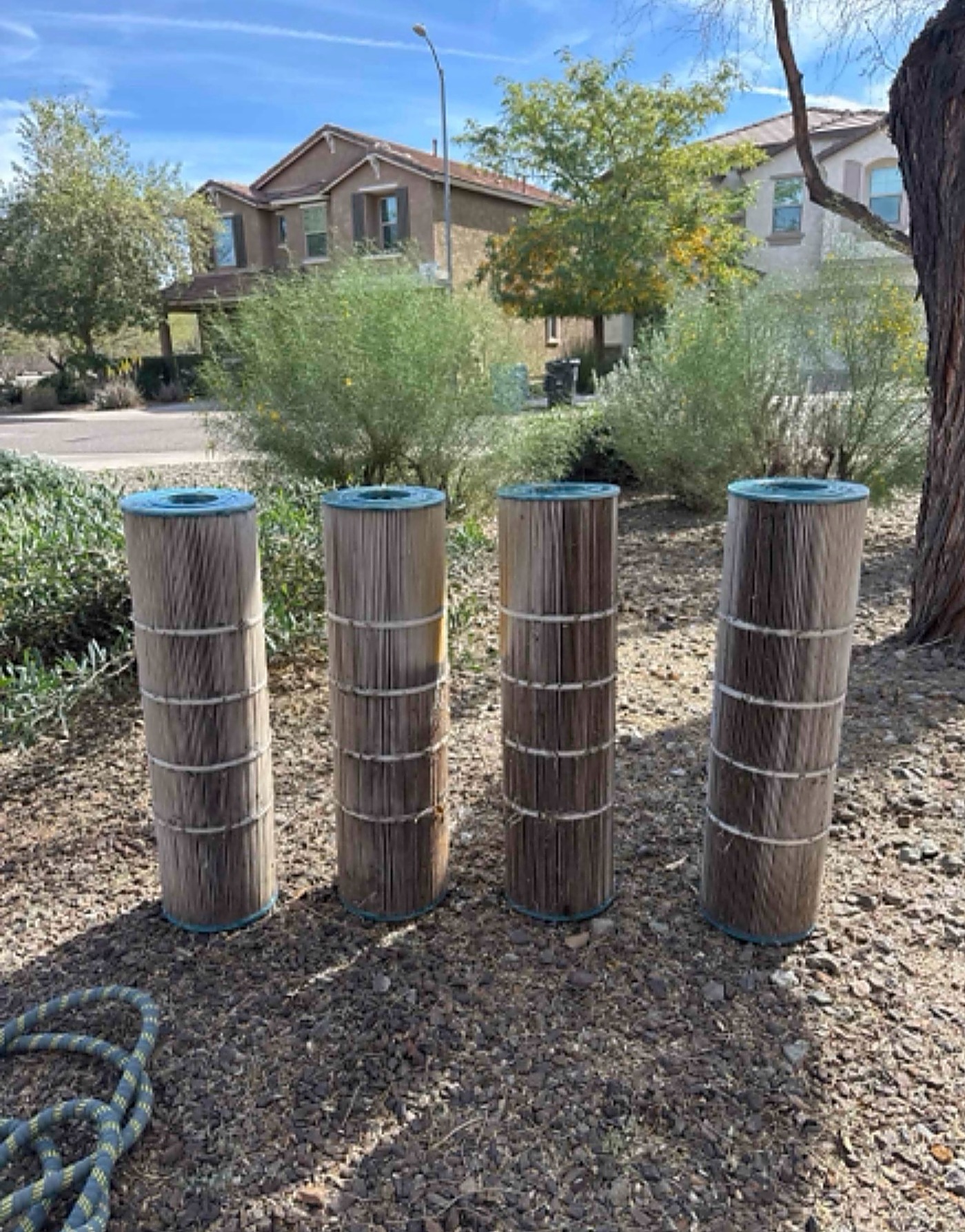 Before: four heavily soiled cartridge filters caked brown with debris